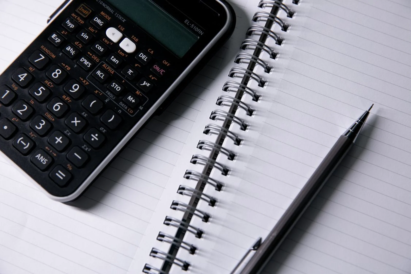 Notebook, calculator and pen on a desk